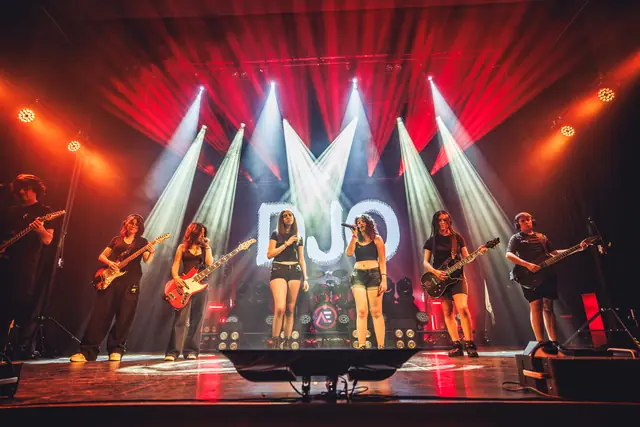 Banda tocando con luces rojas